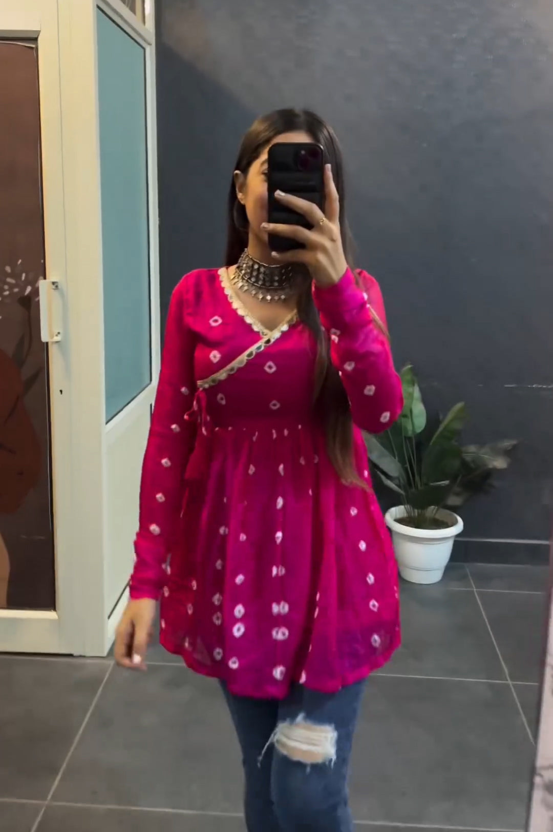 Woman wearing pink bandhni print flared short kurti